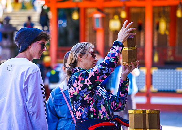 Tourist drawing stick from wooden cylinder