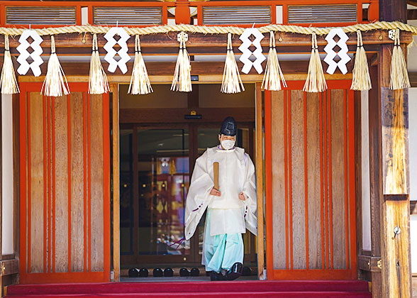 Male priest stepping out of a shrine