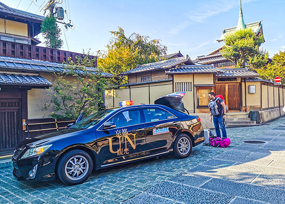 A visitor is unloading his luggage from a Kyoto's taxi