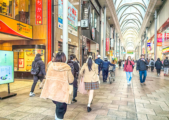 Customers walking past the shops on the sides of the street