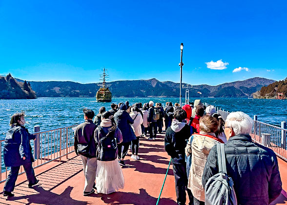 Tourists stand on the deck of the cruise